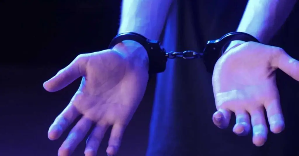 Hands in handcuffs against a blurred background, symbolizing arrest and legal implications in Fort Lauderdale criminal defense context.