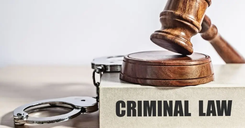 Gavel and handcuffs on a box labeled 'Criminal Law,' symbolizing legal representation and employment rights in criminal cases.