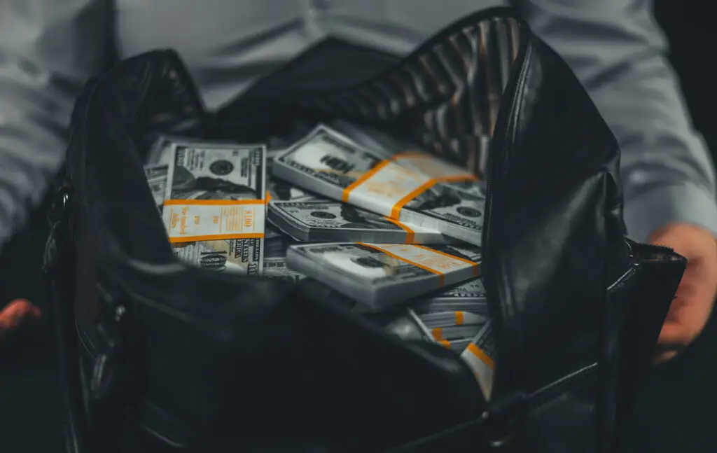 Bag filled with stacks of cash, representing the value of property involved in grand theft cases under Florida law.
