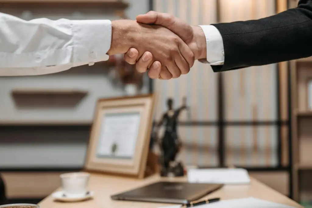 Handshake between a criminal defense attorney and a client in a law office, symbolizing legal partnership and support after an arrest in Broward County, Florida.