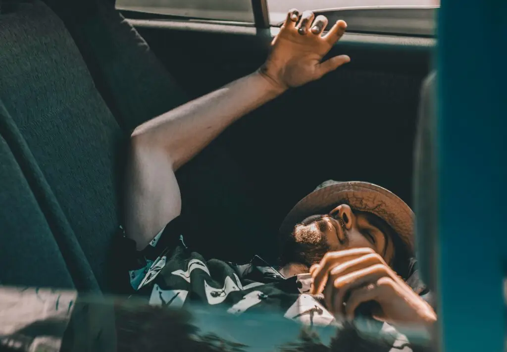 Man sleeping in the back seat of a parked car — example of a DUI arrest scenario without actual driving in Florida