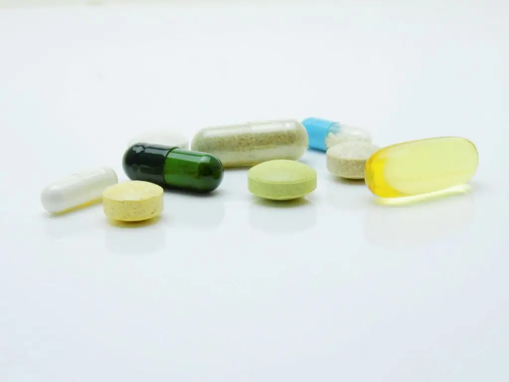 Assorted prescription pills and capsules on a white surface, representing felony drug possession without a prescription in Florida.