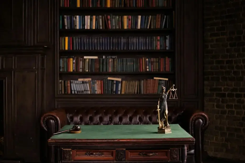 Law office interior featuring a wooden desk with a gavel and a Lady Justice statue, surrounded by shelves of law books, reflecting legal defense strategies for DUI cases in Florida.