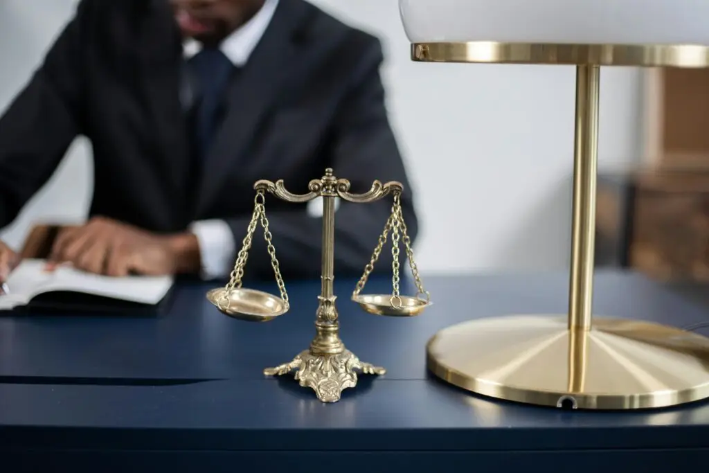 Lawyer at desk with scales of justice and lamp, symbolizing legal representation for misdemeanor cases in Florida.