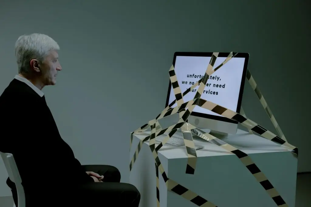 Older man facing a taped-off computer screen displaying a rejection message, symbolizing how a felony drug conviction in Florida can block employment opportunities.