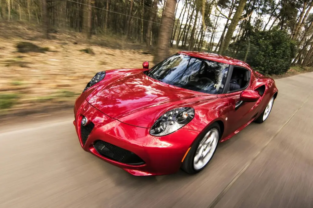 Red sports car speeding down a wooded road — possible criminal speeding in Florida