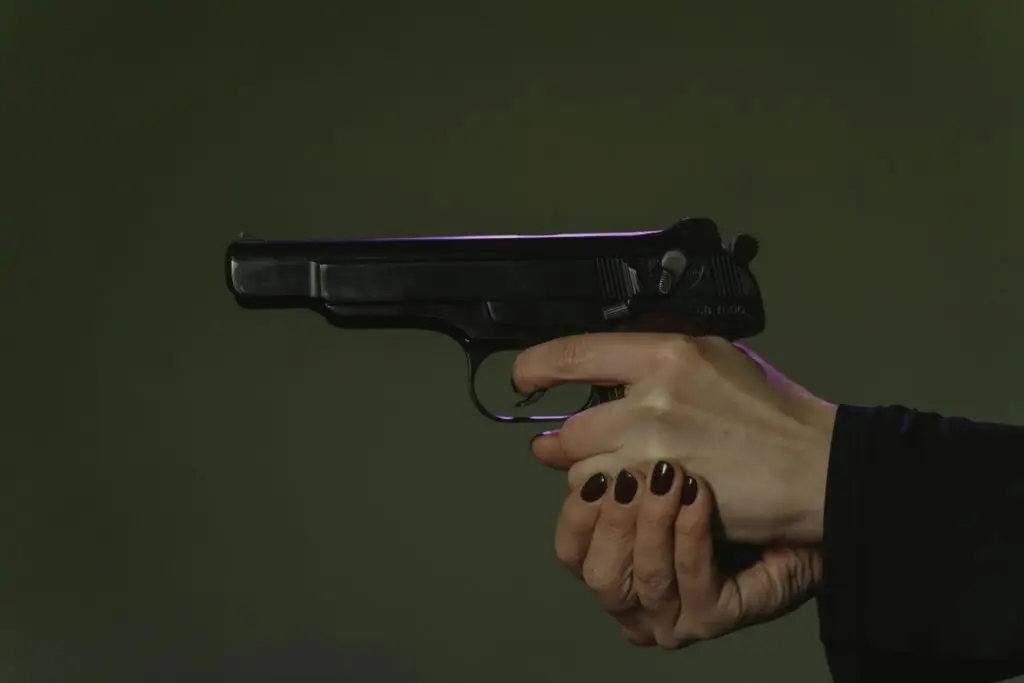 Close-up of a person holding a handgun, illustrating firearm possession issues relevant to a Fort Lauderdale gun crime lawyer.